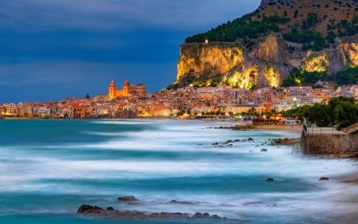 Sicily beach R964WT Blue hour scene of Cefalu town, with blurry sea surface and illuminated mountain in Sicily island, Italy